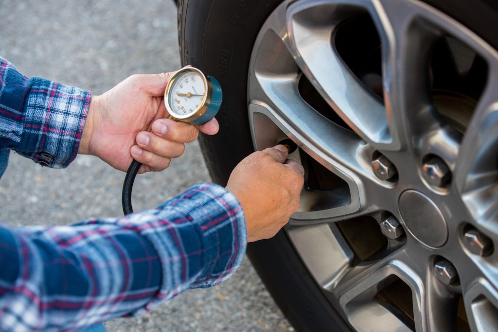 A person checking Tire pressure